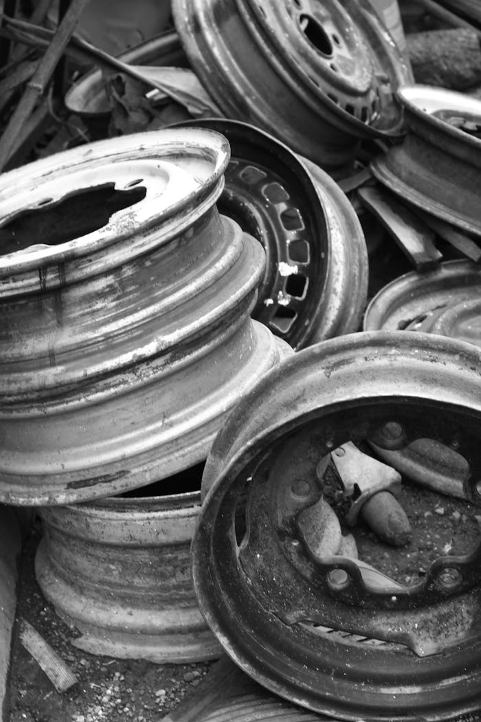 gallery-3 Black and white photo of stacked rusty steel wheels in an industrial setting.