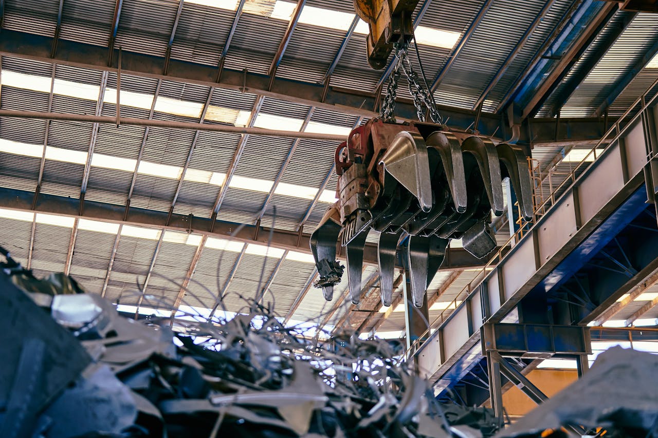 about-01 Interior view of a facility with a crane handling metal scrap.