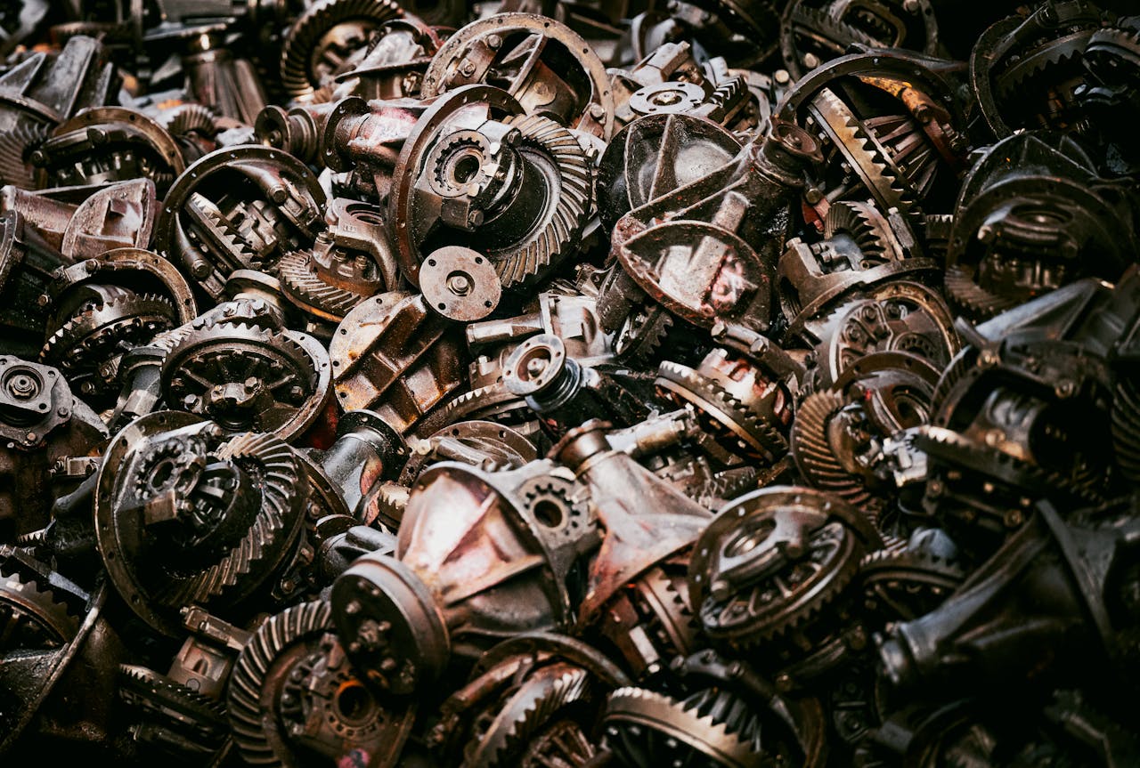 gallery-5 A heap of old mechanical gears in a Bangkok junkyard, showcasing industrial decay.